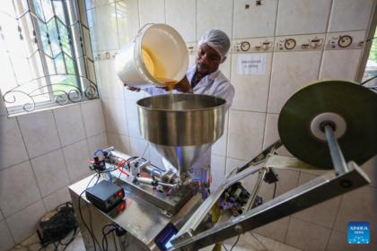 Jackson Mponela, production manager for commerce and development at Tanzania Future Enterprises Company Limited, prepares to package honey in bottles at a factory in Dar es Salaam, Tanzania,